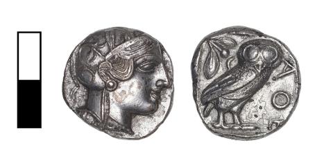 The front and backside of a small silver coin, the front side with the head of a woman, the back side with an owl.