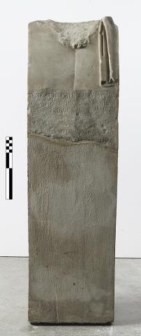 A Large rectangular marble fragment with the remains of a depiction of a beard and clothing at the top, and lines of Greek lettering towards the bottom