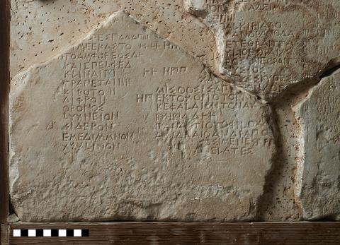 A fragment of a marble slab with organized lines of Greek lettering