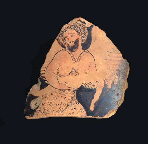 Roughly triangular fragment of red-figure pottery. A bare-chested, bearded Daedalus cradles the body of his son Icarus. Daedalus wears a patterned, flowing garment. His wings are attached by ropes over his shoulders. The image of Icarus has been damaged so that only the outline remains. One of his arms dangles. 