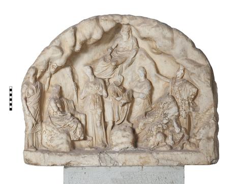 A half-moon shaped marble slab with a relief sculpture of a cave containing several figures and an animal