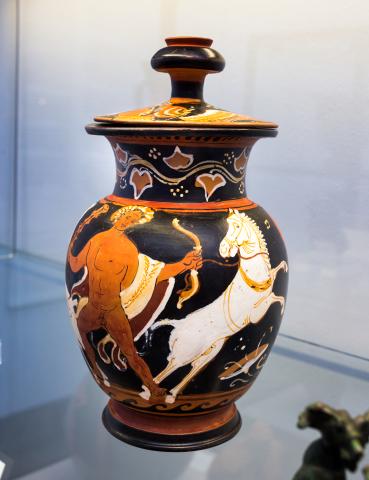 A nude Hercales (left) faces front holding a bow in his left hand and club in his right. There is an animal-skin cloak draped over his arms, white on the exterior, dark red on the interior. A halo of light circles his head. A white horse, wearing a bridle, rears on the right. Barely visible to the left, on the around the curve of the pot, are two hooves of a second white horse.