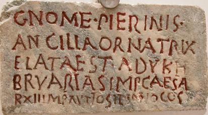 Marble tombstone with incised inscription highlighted by red paint.