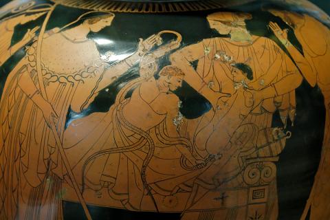 The infants Herakles (center) and Iphikles (right) lie on a bed. The snakes sent by Hera wrap around Herakles' waist while he grasps their throats strangling them. A woman at the head of the bed lifts Iphikles to safety.