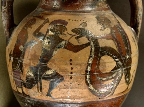 A bearded, armored Cadmus(?) wearing a crested helmet holds a snake or dragon by the neck with his left hand and raises his sword with his right. The snake's mouth is open and its forked tongue is sticking out. On the far right, another bearded and helmeted soldier assists be grabbing the snake from behind. On the far left, behind Cadmus, stands a beared man holding a staff or crook and wearing a cloak.