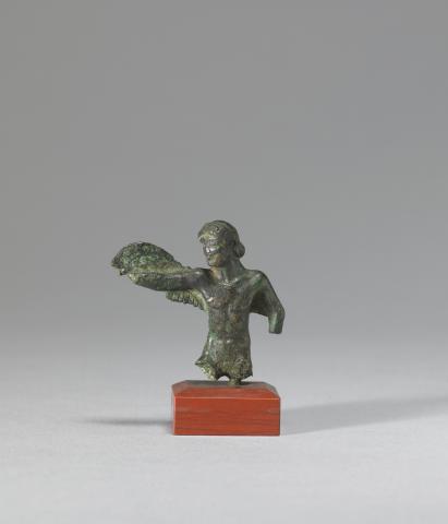 Head and torso of a nude man. He is facing the viewer, right arm outstretched with a wing attached to it by a strap. The hand appears to have broken off. His right arm is lowered, elbow slightly bent. Most of the forearm and hand are missing. The legs are also missing.