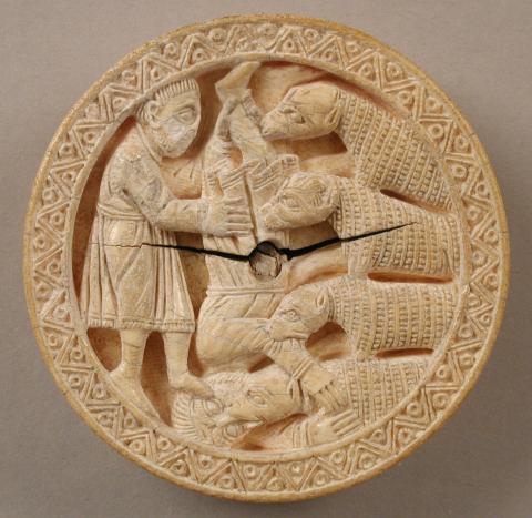 A circular game piece decorated with a bearded Heracles holding Diomedes upside down by his ankle as four horses bite into him. Heracles and Diomedes are dressed in mid-calf length tunics. Diomedes grasps one of the horses by its neck as it attacks his face. A second bites his arm, the remaining two his leg. The horses' heads look more like dogs; their coats are rendered by lines of etched squares. A geometric border is covered around the edge.
