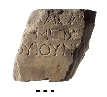 A rhomboid fragment of marble with lines of Greek lettering inscribed.