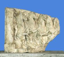 A section of marble with relief sculpture of an organized line of horses with riders.