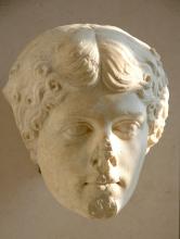 Sculpted marble head of Agrippina the Elder. Her hair is parted in the center with a slight wave to it. Beginning just above the temple it is styled in loose curls. The head has sustained damage: the nose and point of the of chine are largely missing and the lips have been chipped as well. 