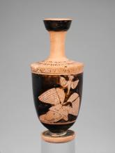 A nude youth with wings faces down his hands appear to be clasped on his chest, but the finish is damaged. Above him a bird flies, head down with beak pointed to the youth.