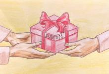 A square, pink package tied with a darker pink bow is centered on a light yellow background. its is supported by two light-skinned hands on the left and one light-skinned hand on the right. Written on the edge of the package's lid, across one of the corners is the word "donum."