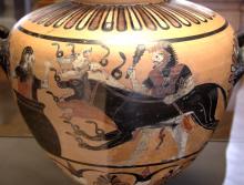 Herakles (left), wearing his lion skin, holds his club in his right hand, and Cerberus' leash in his left. Cerberus (center) lunges toward a large storage jar (left) in which Eurystheus is hiding. Snakes coil in front of Cerberus' snouts and front paws.