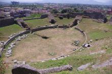 oval shaped clearing surrounded by low stone wall and rising grassy seating area