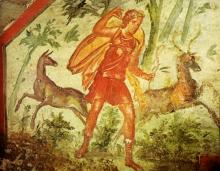 Diana stands (foreground center) in a forest flanked by two deer in the background. She holds a bow in her left hand and reaches over her shoulder to draw an arrow from her quiver with her right hand. She is dressed in a knee length tunic and calf-high boots. 