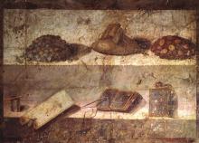 Fresco in two registers, depicting two shelves. On the top shelf a bag, probably containing coins, sits in the center flanked on one side by a pile of silver coins and on the other gold. On the lower shelf, an inkwell sits far left with a stylus balanced across the left. next to lays a scroll. To the right of the scroll is an open set of wax tablets with a second stylus. Far right, a closed set of wax tablets.