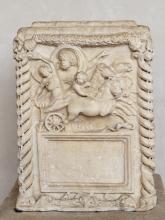 The face of the altar is divided into two registers. The upper register illustrates the rape of Proserpina (Persephone) by Dis (Hades). Dis (left) stands in a four-horse chariot driven by a cupid (center right). He grabs Proserpina by the waist sweeping her up into the chariot with his right arm. One of her feet is just visible behind the chariot. Proserpina's left arm is thrown over her head, her right is outstretched behind her. 