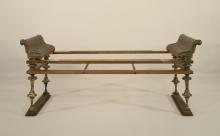 Wooden bed frame of a Roman banquet couch. The scrolled arm rests at either end are decorated with bronze fittings in the shop of lions' heads. The legs are also of bronze terminating in a wooden base.