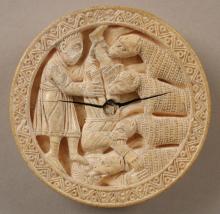 A circular game piece decorated with a bearded Heracles holding Diomedes upside down by his ankle as four horses bite into him. Heracles and Diomedes are dressed in mid-calf length tunics. Diomedes grasps one of the horses by its neck as it attacks his face. A second bites his arm, the remaining two his leg. The horses' heads look more like dogs; their coats are rendered by lines of etched squares. A geometric border is covered around the edge.